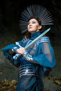 Portrait of a young woman  medieval knight standing with a sword fantasy cosplay