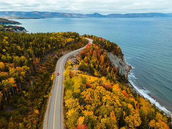 Aerial view of a road tripper in scotch head during autumn, cape breton island, nova scotia, canada