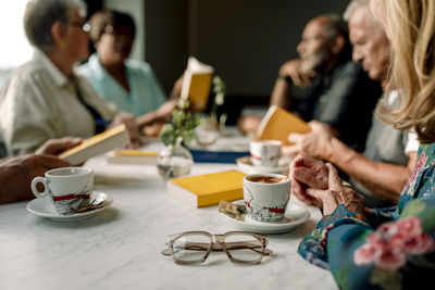 Senior male and female friends sitting together in cafe