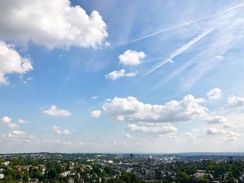 Aerial view of cityscape against blue sky