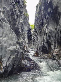 Scenic view of rocks in sea against sky