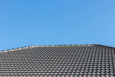 Low angle view of building roof against clear sky