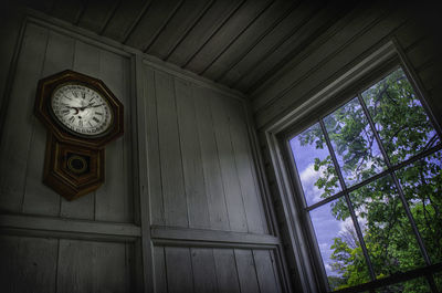 Low angle view of clock on window