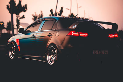 Vehicles on road at sunset
