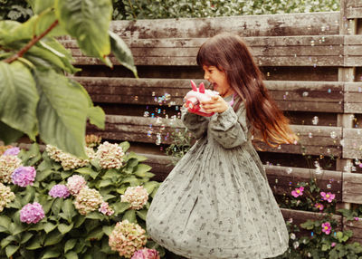 Side view of young woman with bouquet