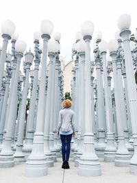 Full length of young woman standing against sky