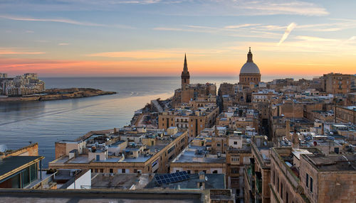 View of buildings in city at sunset