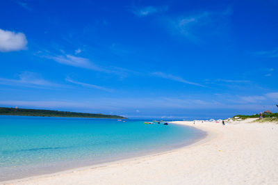 Scenic view of beach against blue sky