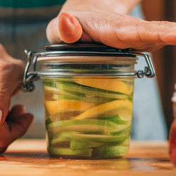 Woman holding jars with fermented fruits.