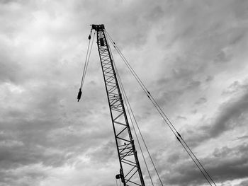 Low angle view of silhouette cranes against sky