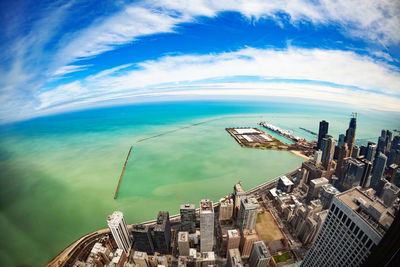 High angle view of cityscape by sea against sky