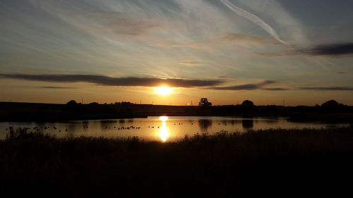 Scenic view of lake against sky during sunset