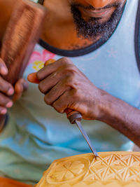 Man at work, making a wooden hand carving