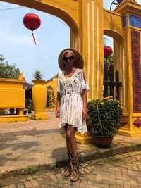 Portrait of woman wearing sunglasses standing on road