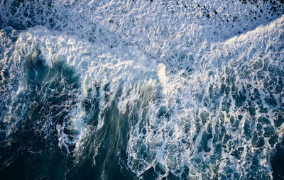 Waves rolling over shore in sea