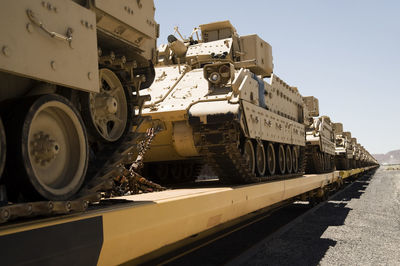 Machines of war heading east on flatbed train cars
