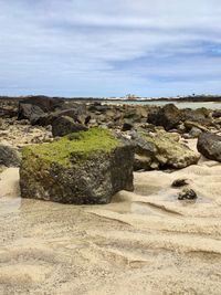 Scenic view of rocks on beach against sky