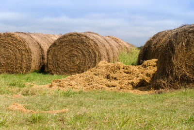 Hay bales on field against sky