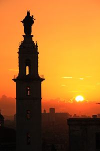 Statue in city during sunset