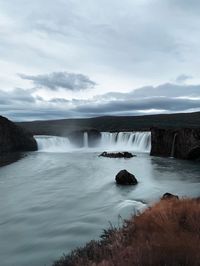 Scenic view of waterfall against sky