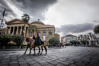 Panoramic view of street by buildings against sky