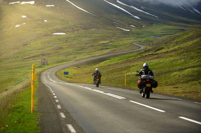 People riding motorcycle on road