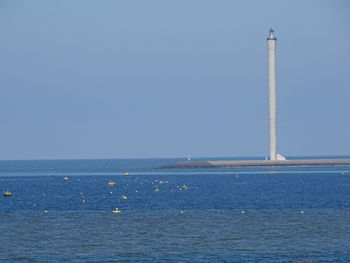 Sailboat in sea against clear blue sky