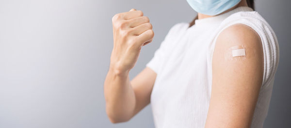 Midsection of woman standing against white background