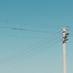 Low angle view of power line against blue sky