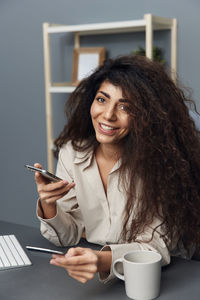 Smiling businesswoman doing online shopping at office