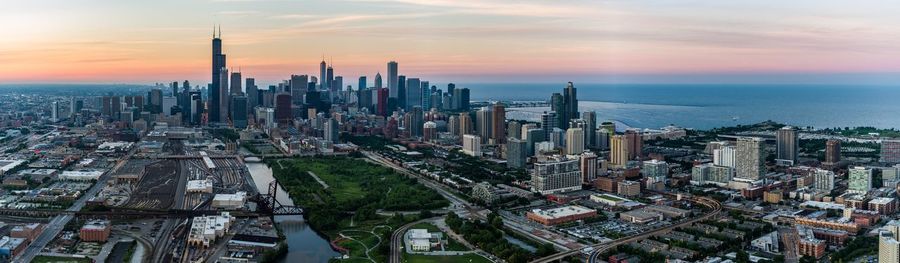 Aerial view of buildings in city against cloudy sky