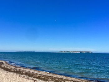 Scenic view of sea against clear blue sky