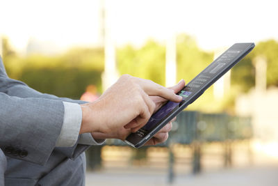 Midsection of man using mobile phone