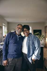 Portrait of smiling senior couple standing with each other at home