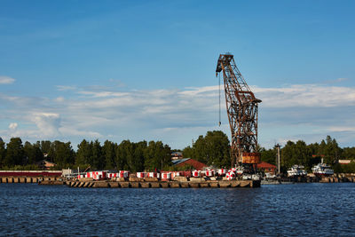 Ferris wheel by river against sky