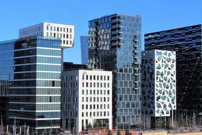 Low angle view of office buildings against blue sky