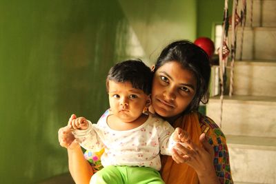 Portrait of mother and daughter sitting at home