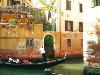 People on boat against buildings in city