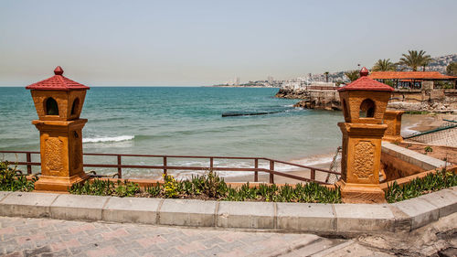 Built structure by sea against clear sky