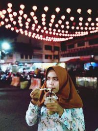 Mid adult man holding ice cream at night