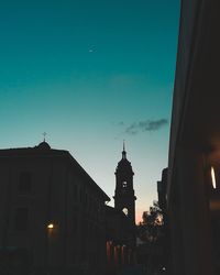 Illuminated buildings against sky at dusk