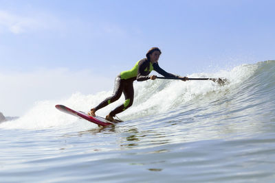 Female sup surfer on a wave