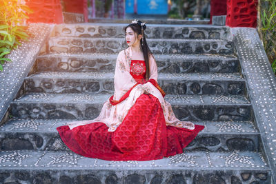 Rear view of woman sitting on staircase