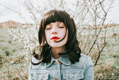 Portrait of young woman against plants