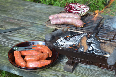 Hibachi tabletop grill with brats, raddichio, italian sausages outdoors picnic