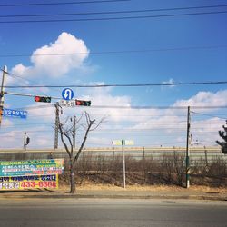 Road sign against cloudy sky