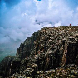 Low angle view of rock formation against cloudy sky