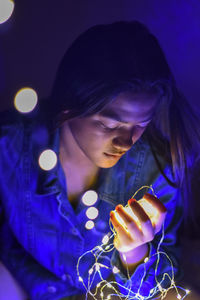 Close-up of man using mobile phone at night