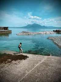 Man standing on sea shore against sky