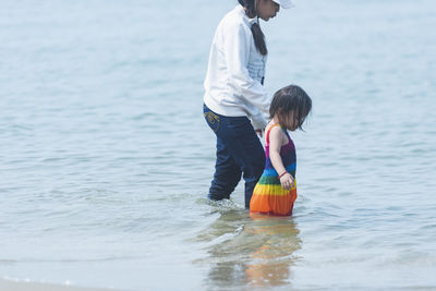 Rear view of woman standing in sea